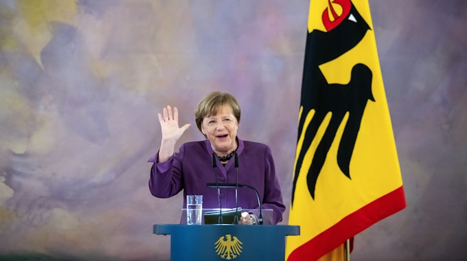 Altkanzlerin Angela Merkel steht an einem Rednerpult und gestikuliert während einer Rede.