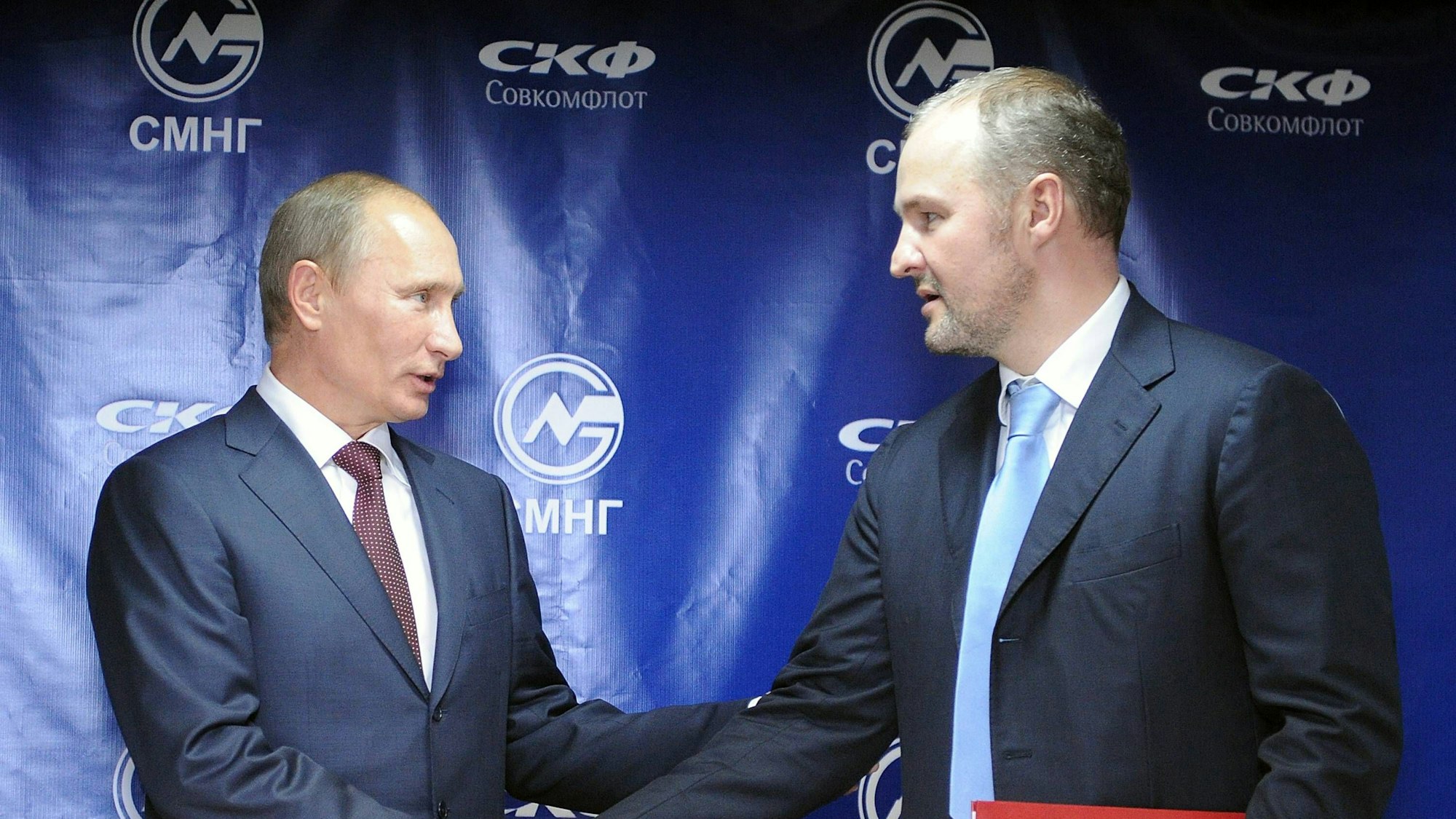 Eine Aufnahme aus dem Jahr 2011: Wladimir Putin und Roman Trotsenko schütteln sich nach einem Geschäftsabschluss die Hände. (Archivbild)