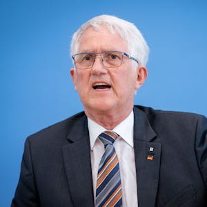 Georg Schirmbeck, Präsident des Deutschen Forstwirtschaftsrates, steht vor einer blauen Wand und gestikuliert.