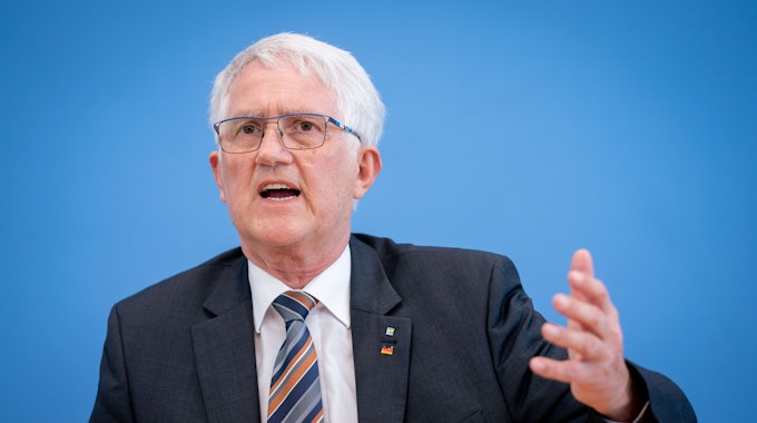 Georg Schirmbeck, Präsident des Deutschen Forstwirtschaftsrates, steht vor einer blauen Wand und gestikuliert.
