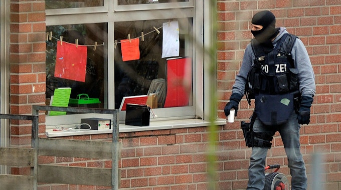 Ein Beamter eines Spezialeinsatzkommandos (SEK) der Polizei blickt am durch ein Fenster in eine Kindertagesstätte, in der es zu einer Geiselnahme gekommen ist.&nbsp;