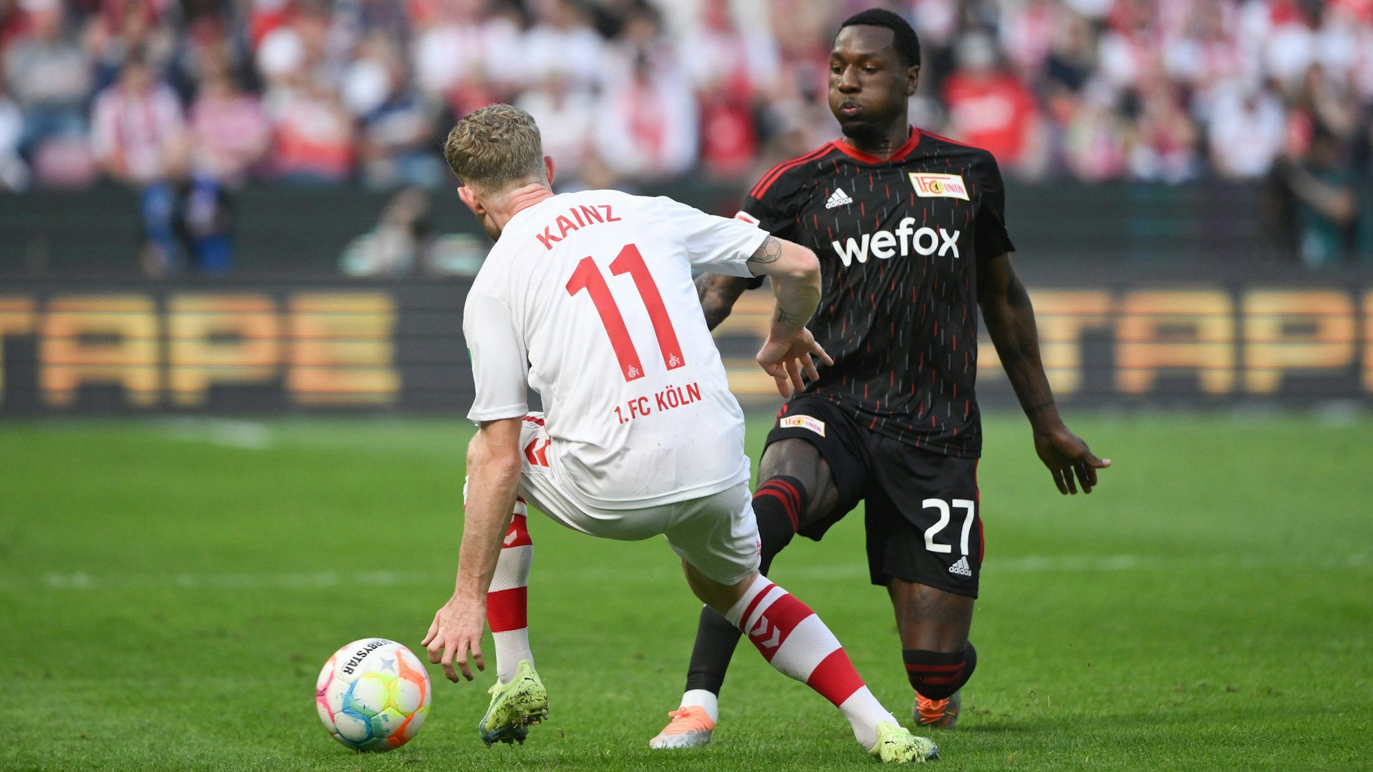 Sheraldo Becker legt den Ball im Spiel zwischen dem 1. FC Köln und Union Berlin an Florian Kainz vorbei.