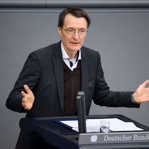 Bundesgesundheitsminister Karl Lauterbach gestikuliert am Rednerpult des Deuschen Bundestag.