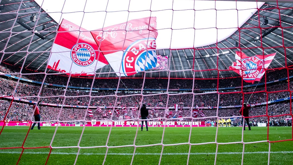 Fahnen des FC Bayern München werden vor dem Spiel in der Allianz-Arena geschwenkt.