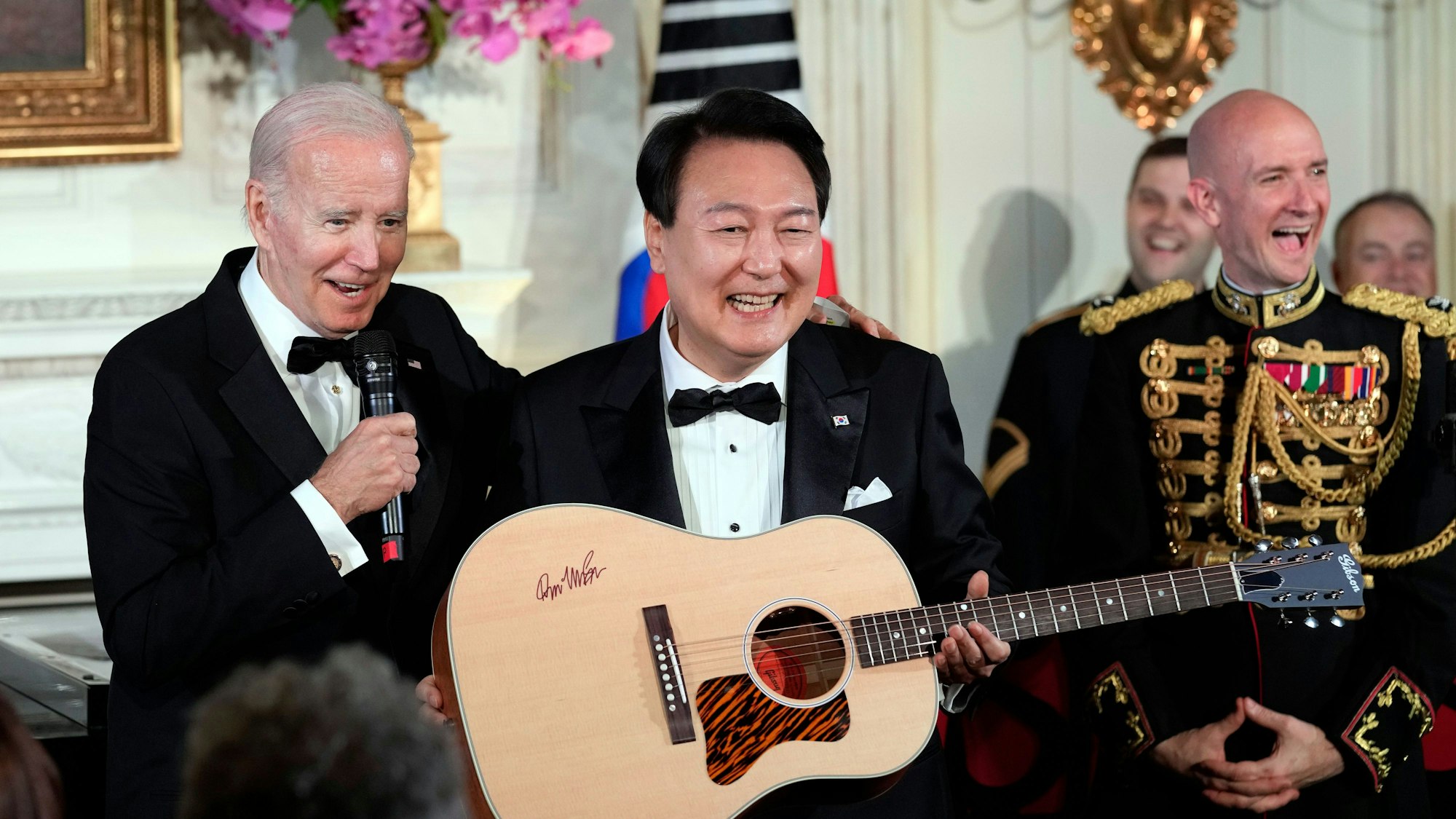 US-Präsident Joe Biden (l) überrascht Yoon Suk Yeol, Präsident von Südkorea, nach dem Staatsdinner mit einer von Don McLean signierten Gitarre im East Room des Weißen Hauses in Washington. American Pie von McLean ist einer der Lieblingssongs von Yoon.