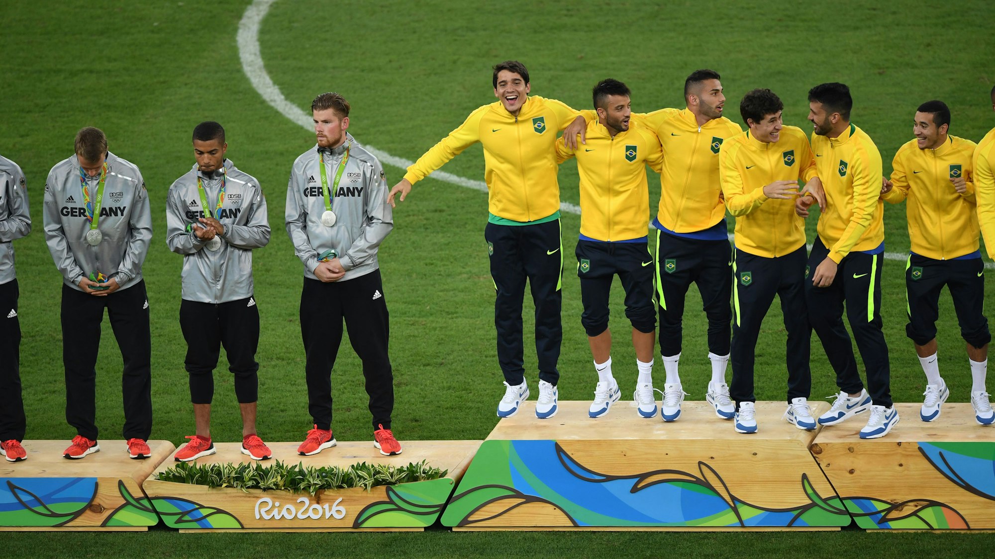 Das deutsche Team (l.), enttäuscht über das verlorene Finale, steht neben den jubelnden Brasilianern
