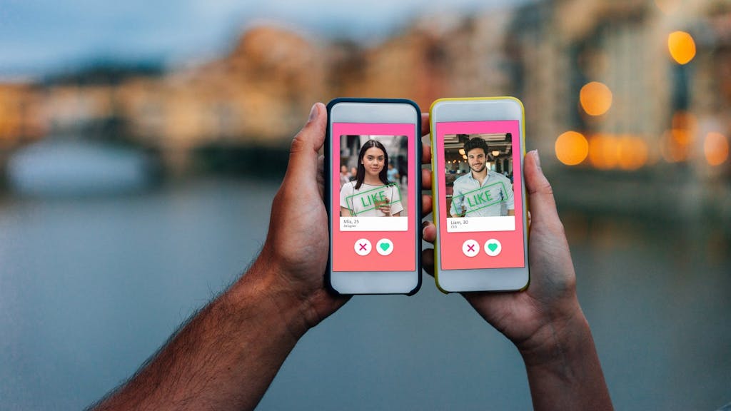 Zwei Hände, die Smartphones mit einer Online-Dating-App auf dem Bildschirm halten.