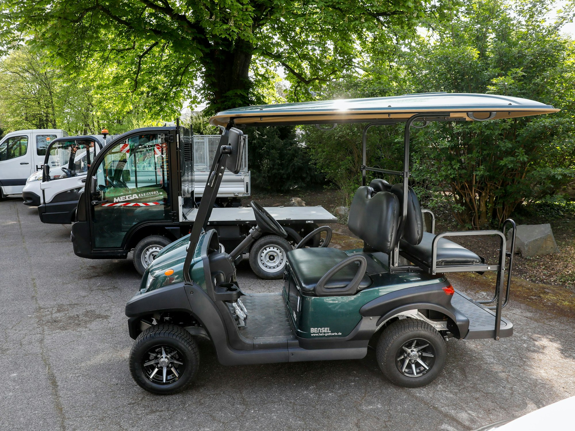Ein Elektro-Fahrzeug der Kölner Grünpflege steht in einem Kölner Park.