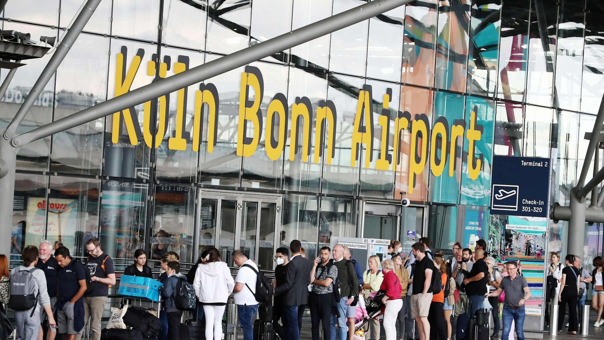 Flughafen Köln Bonn, Fluggäste in der Warteschlange, die bis vor das Flughafengebäude reicht, 01.07.2022, Bild: Herbert Bucco

