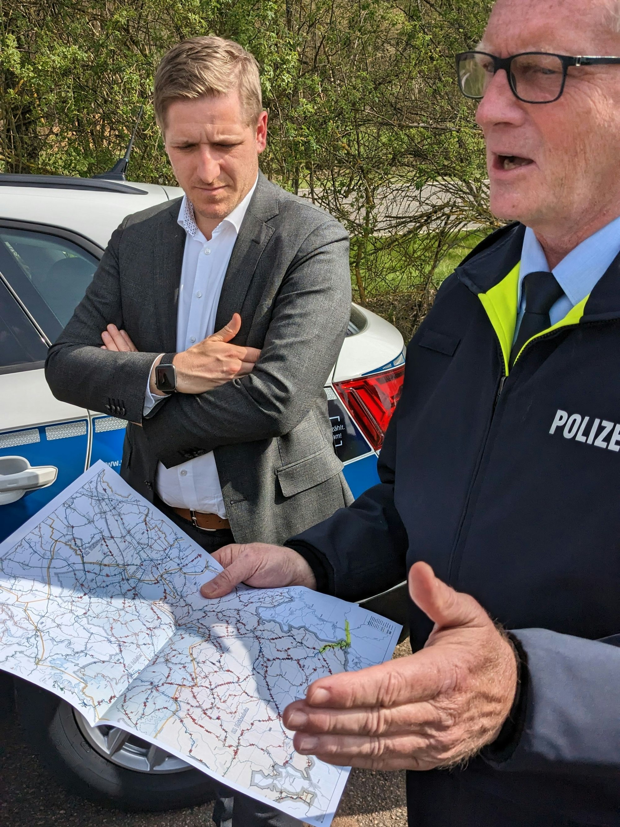 Polizeioberrat Wolfgang Eifinger (r.) zeigt eine Karte der Straßen, an denen sich Wildunfälle im Kreis Euskirchen häufen.