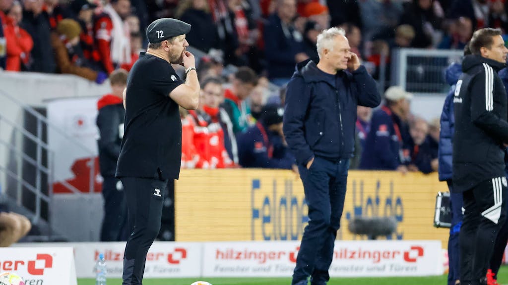 Steffen Baumgart und Christian Streich stehen beim Bundesliga-Spiel SC Freiburg gegen 1. FC Köln an der Seitenlinie.