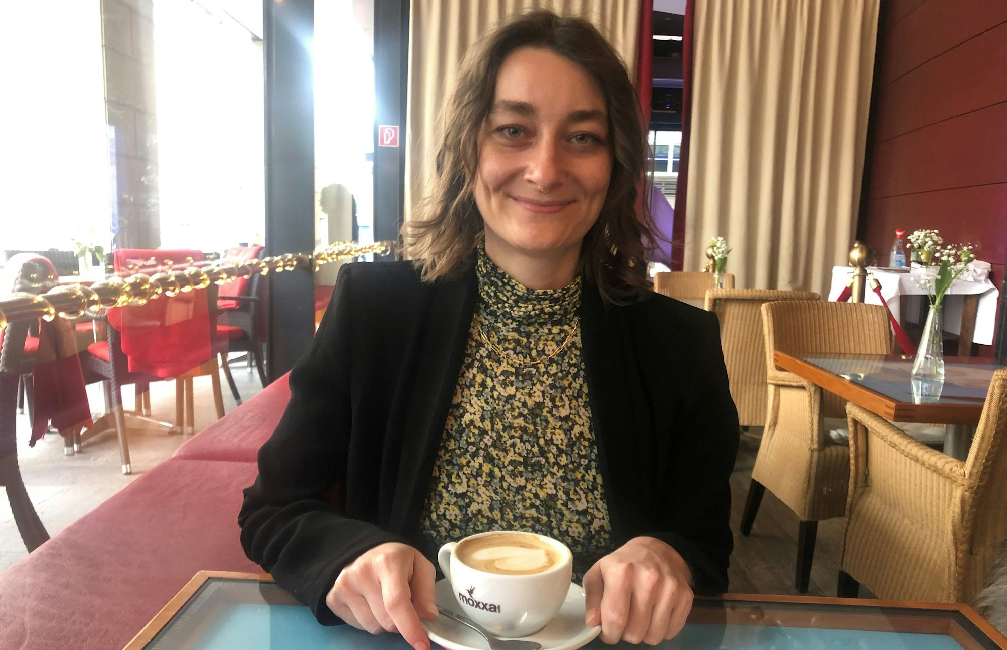 Frau im Café mit Cappuccino