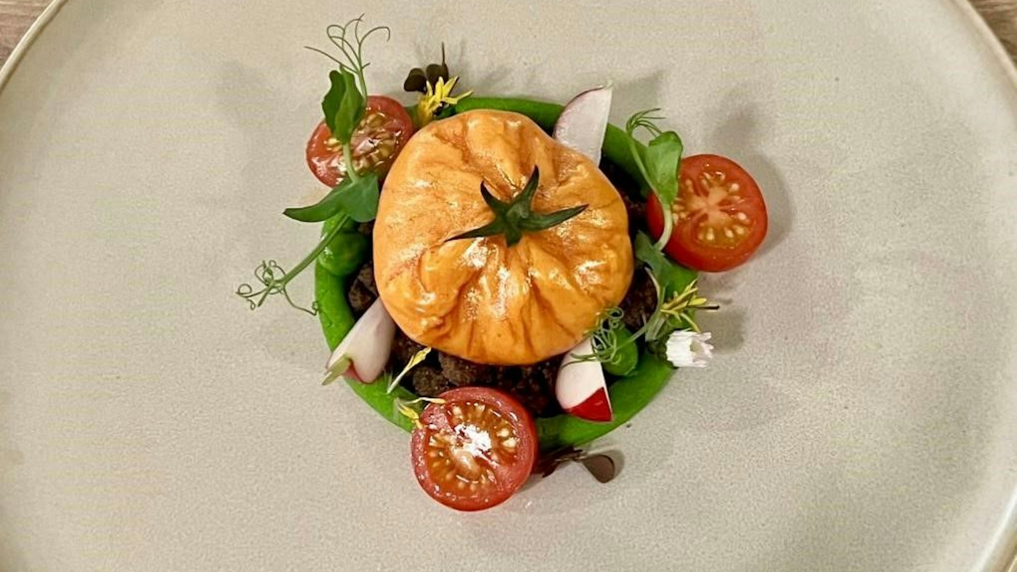 Tomaten in verschiedenen Farben mit Radieschen und Mousse auf einem großen Teller