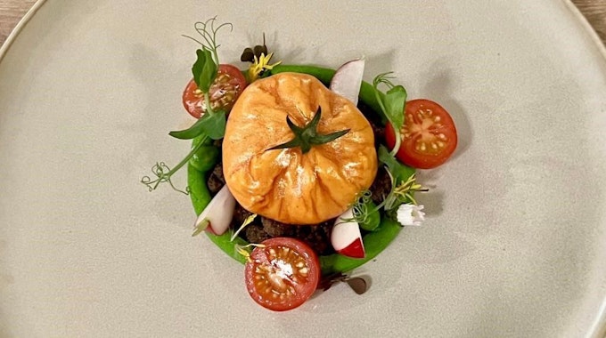 Tomaten in verschiedenen Farben mit Radieschen und Mousse auf einem großen Teller