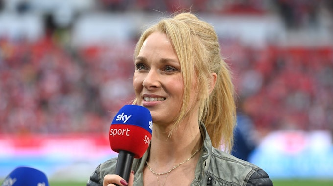 Sky-Moderatorin Britta Hofmann hält ein Mikrofon in der Hand.&nbsp;