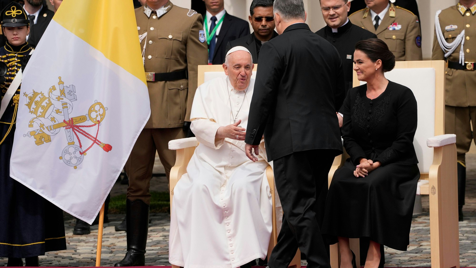 Papst Franziskus (l), wird von Viktor Orban, Ministerpräsident von Ungarn, auf dem Platz vor dem Palais Sandor begrüßt. Rechts sitzt  Katalin Novak, Präsidentin von Ungarn.