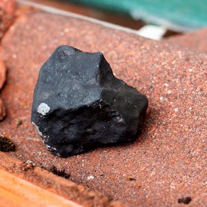 Ein Meteorit hat ein Hausdach in Elmshorn in Schleswig-Holstein durchschlagen. Er liegt auf einer zerbrochenen Dachpfanne.