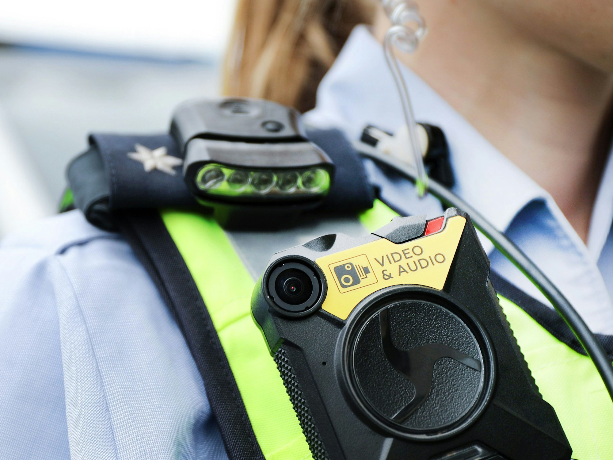 Eine Polizistin trägt an ihrer Weste eine Bodycam.