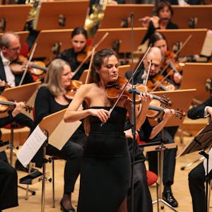 Die italienische Violinistin Nicola Benedetti spielt zur Eröffnung des Acht-Brücken-Festivals am 28. 4. 2023 in der Kölner Philharmonie. Sie trägt ein schulterloses schwarzes Abendkleid.