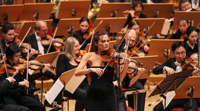 Die italienische Violinistin Nicola Benedetti spielt zur Eröffnung des Acht-Brücken-Festivals am 28. 4. 2023 in der Kölner Philharmonie. Sie trägt ein schulterloses schwarzes Abendkleid.