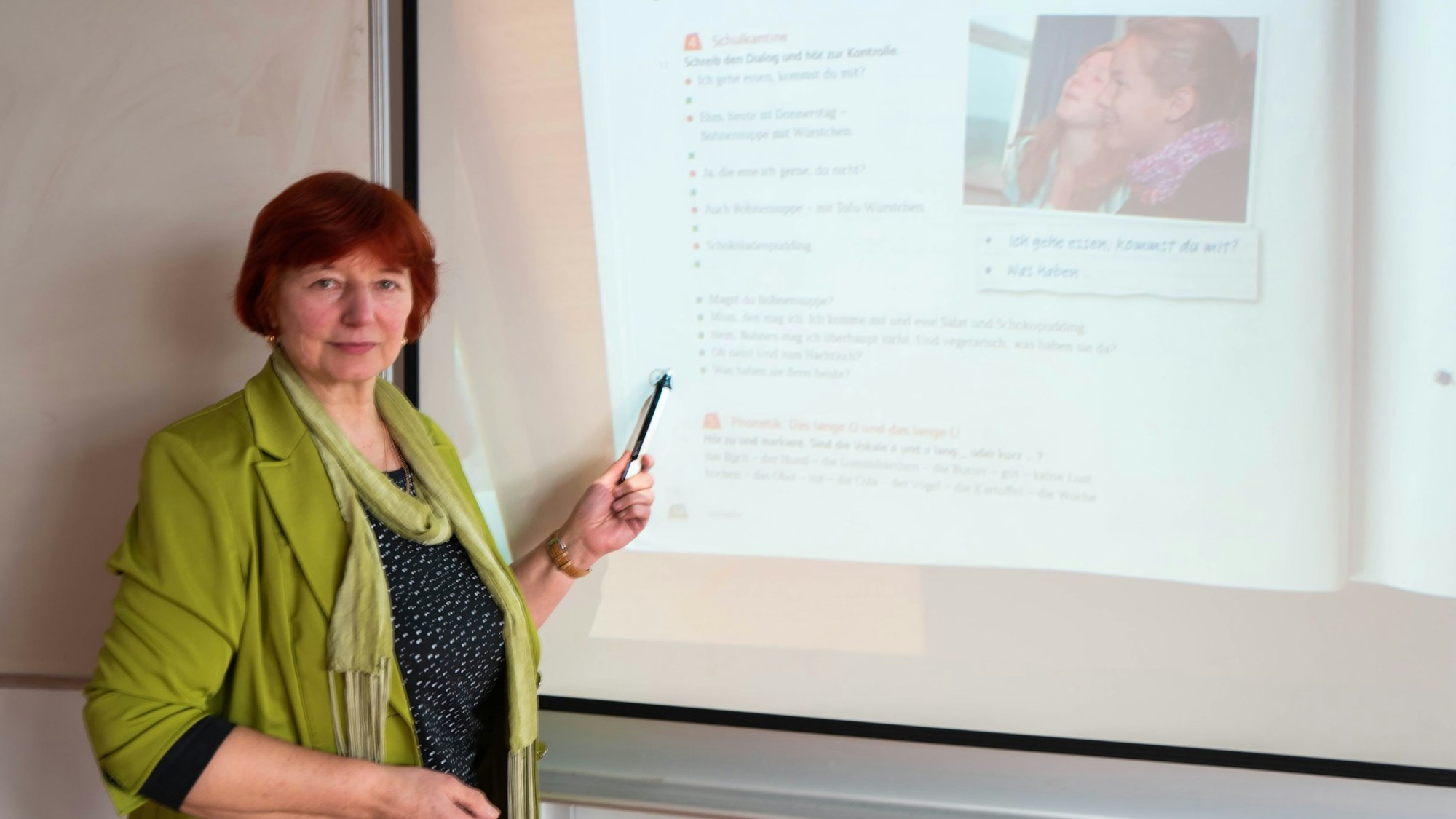 Eine Lehrerin steht an einem Smartboard in einer Schule.