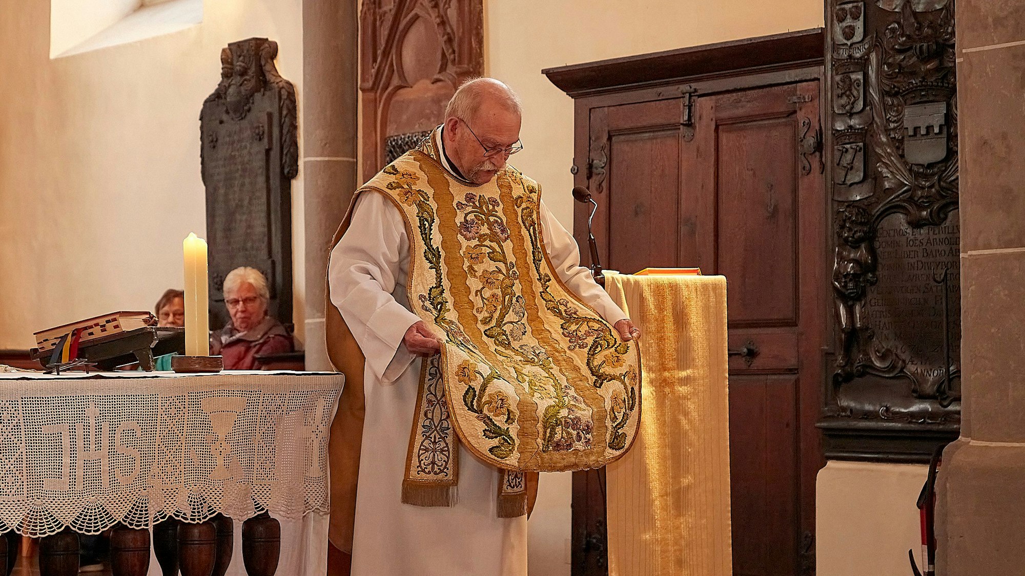 Ein Pfarrer trägt ein altes und wertvolles Messgewand.