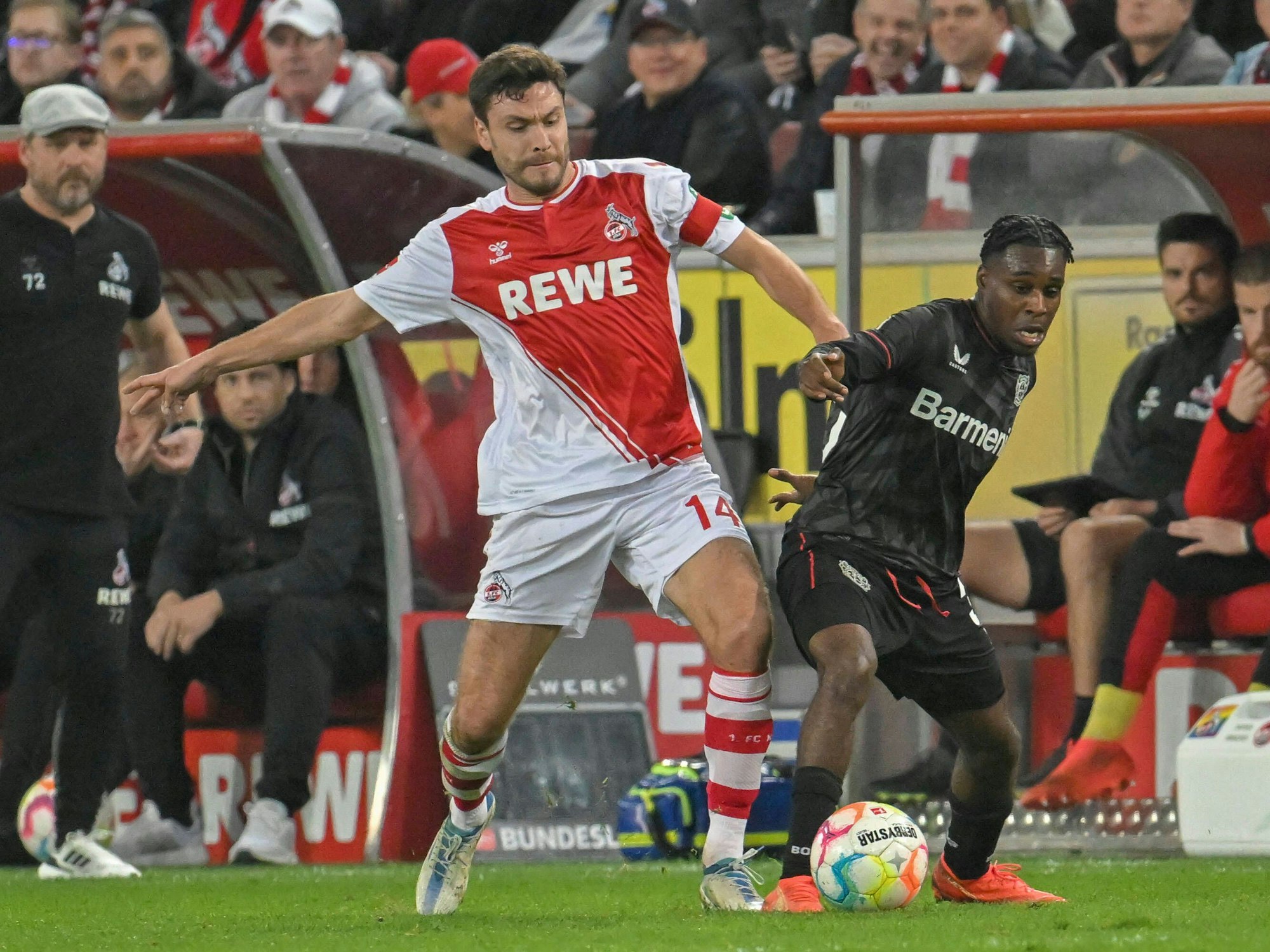 Kölns Jonas Hector und Leverkusens Jeremie Frimpong kämpfen um den Ball.