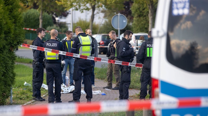 Diverse Polizisten stehen an einem Einsatzort in Dormagen, der Tatort ist urch Flatterband abgesperrt.