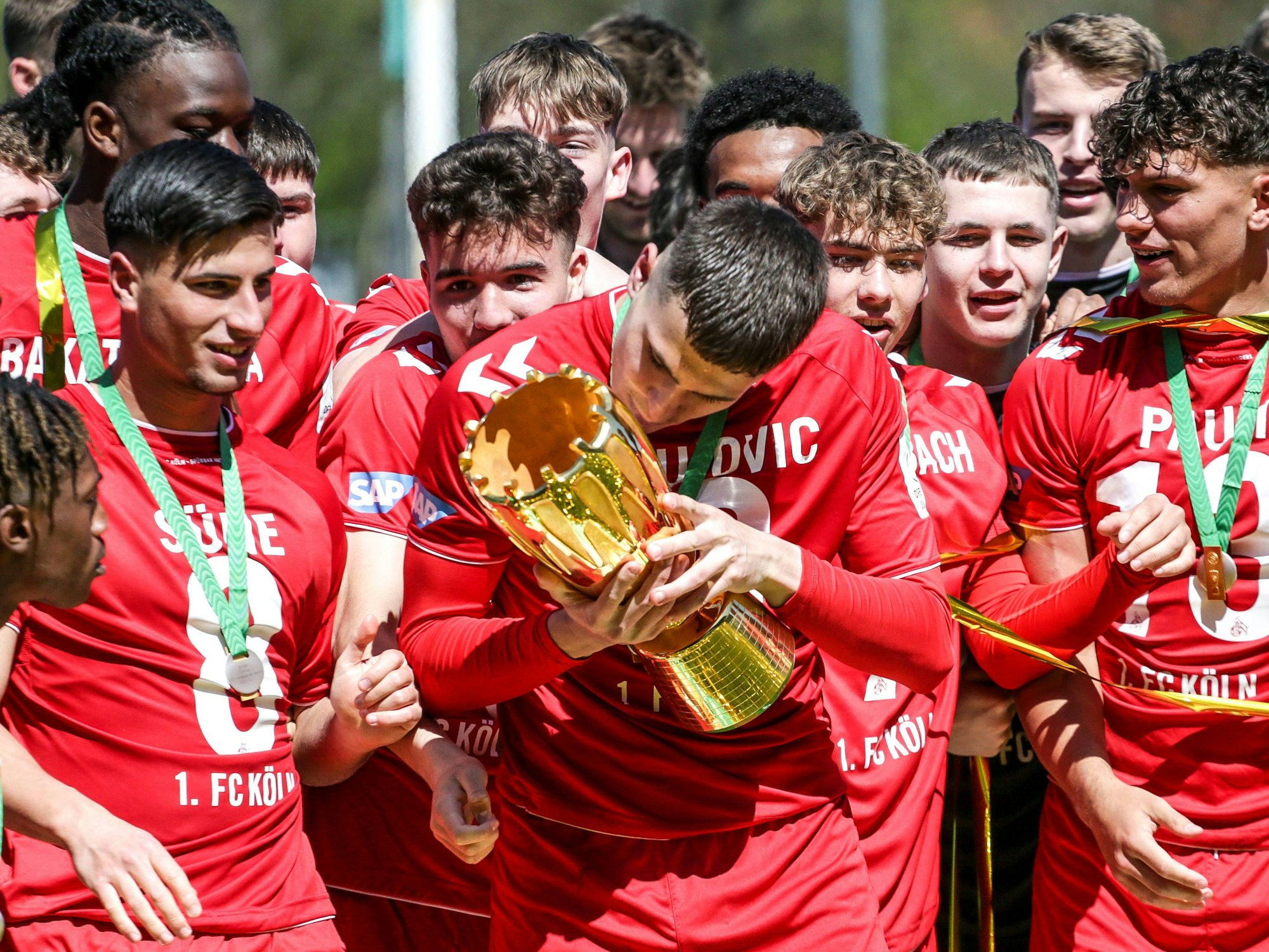 Die Nachwuchs-Talente des 1. FC Köln nach dem Finalsieg (30. April 2023) mit dem DFB-Pokal. Hier küsst Sechser Emin Kujovic die Trophäe.