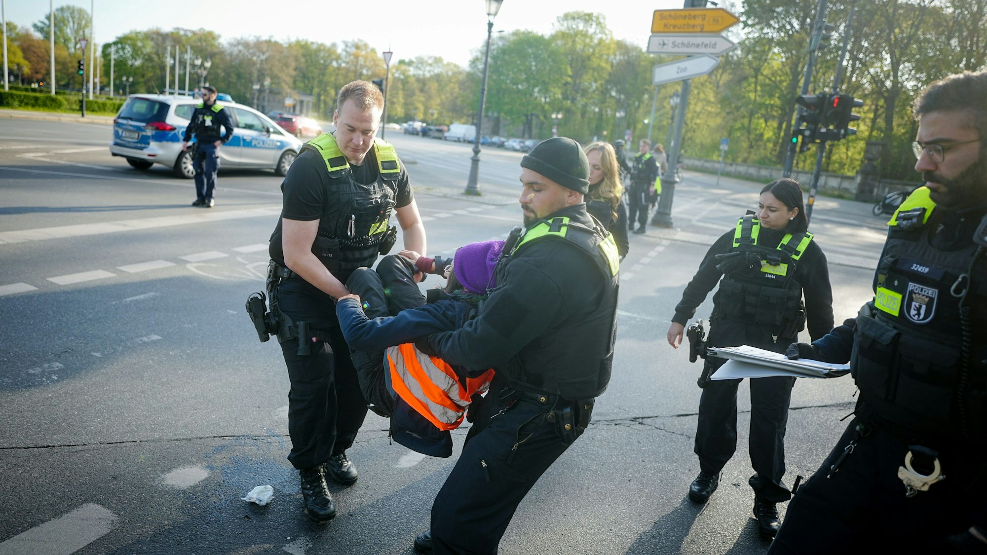 Letzte Generation in Berlin: Polizisten tragen eine Klima-Aktivistin von der Straße.