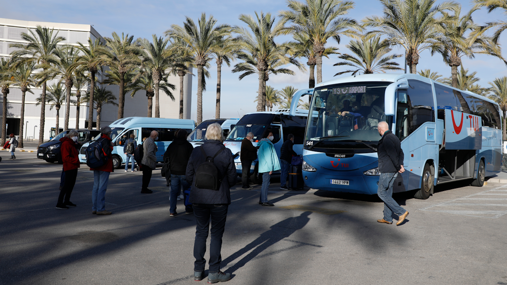 Touristinnen und Touristen, die mit TUI reisen, kommen am Flughafen von Palma de Mallorca an und gehen zu ihren Reisebussen für die Weiterfahrt.