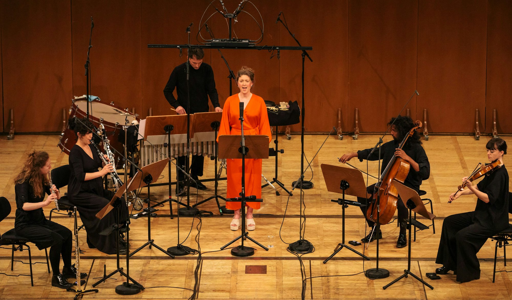 Zola Mennenöh in orangen Jumpsuit singt beim Festival Acht Brücken in Köln mit kleinem Ensemble.