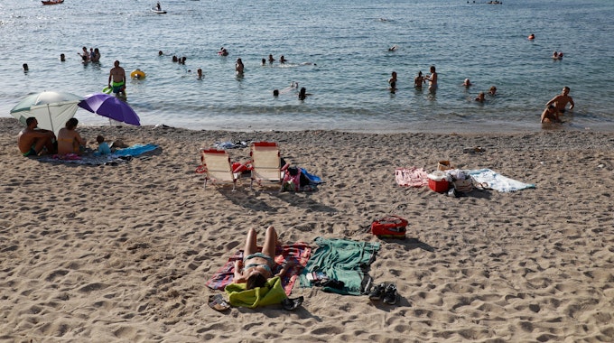 Menschen schwimmen und sonnen sich am Strand Colonia Sant Pere auf Mallorca.