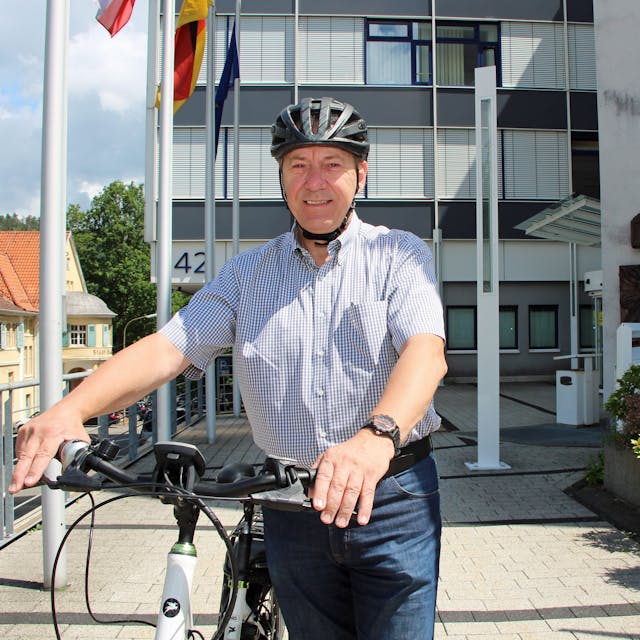 Landrat Jochen Hagt steht mit einem Fahrrad vor dem Kreishaus in Gummersbach.