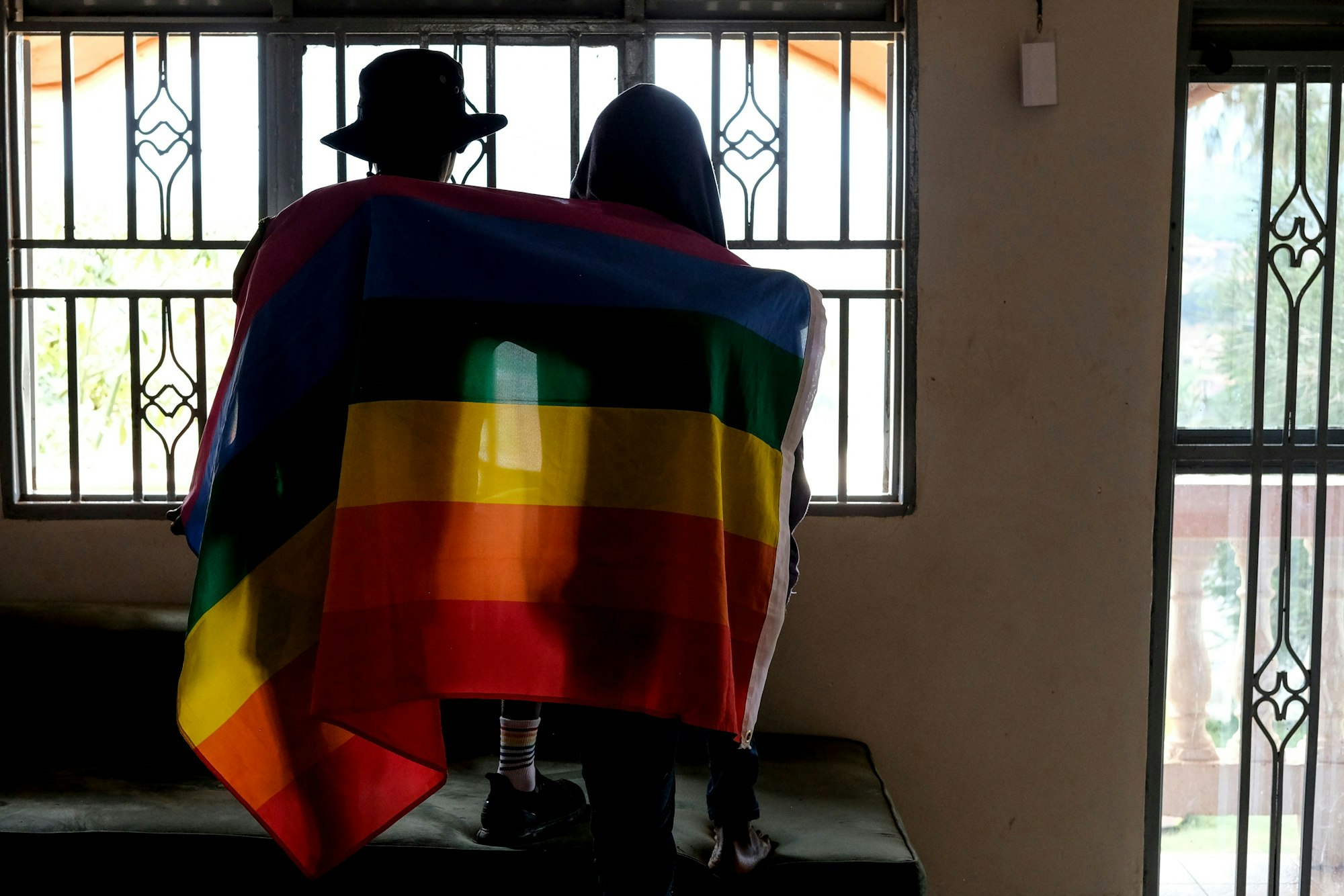 Ein Paar bedeckt sich mit einer Pride-Fahne. In Uganda hat das Parlament ein überarbeitetes Gesetz gegen Homosexuelle verabschiedet.