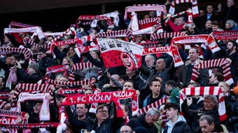 Fans des 1. FC Köln halten zur Hymne der Höhner ihre Schals hoch.
