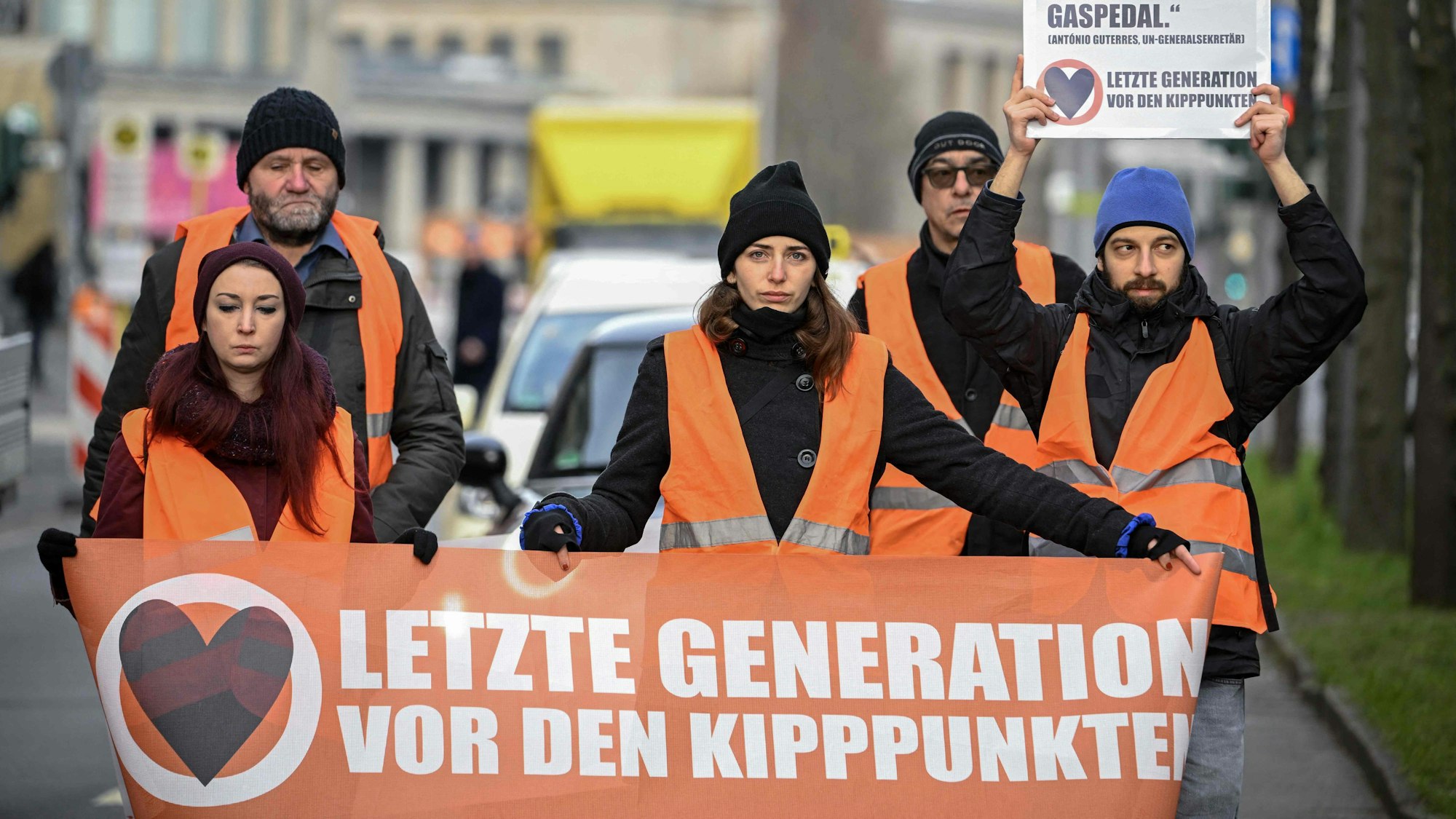 Aktivistinnen und Aktivisten der Gruppe „Letzte Generation“ bei einer Protestaktion in Berlin. Das Unternehmen Ökoworld will nun Strafen für Klebe-Proteste der Aktivisten übernehmen. (Archivbild)