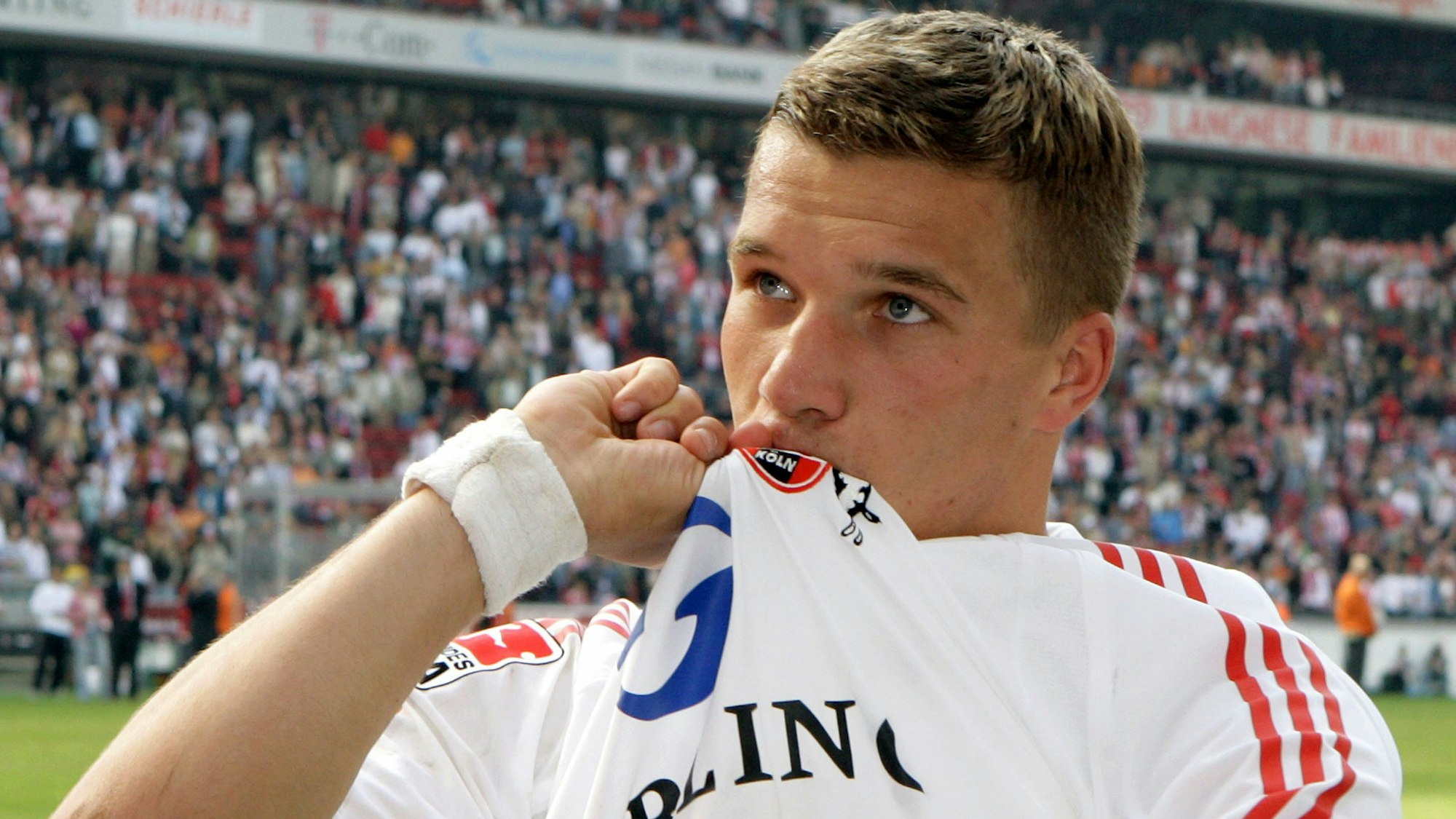 Lukas Podolski küsst das FC-Wappen auf seinem Trikot.