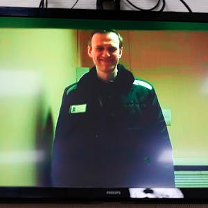 Alexej Nawalny, Kremlkritiker aus Russland, ist per Videolink bei einer Anhörung auf einem Monitor im Moskauer Bezirksgericht Babushkinsky zu sehen. Er lächelt.