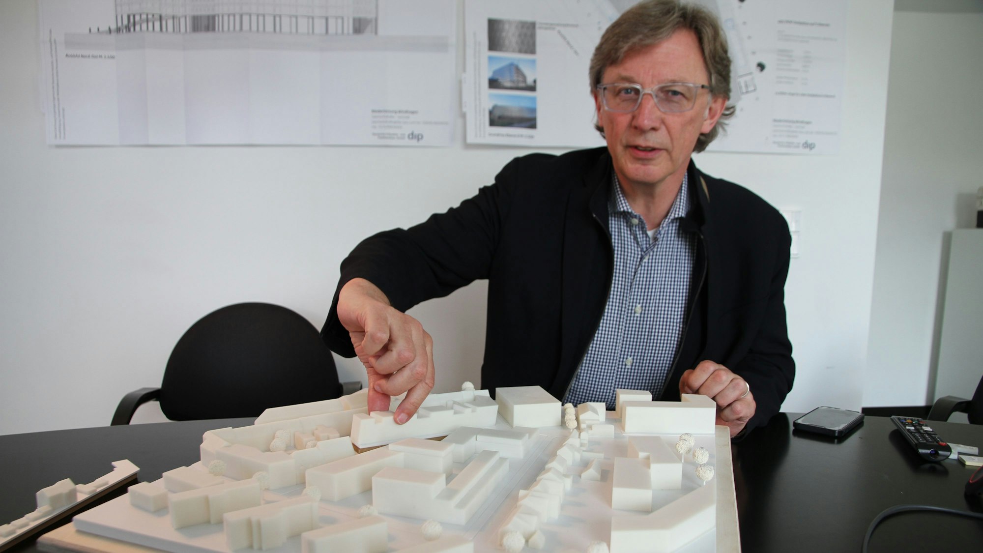 Ein Mann mit einem Architekturmodell für ein Baugebiet