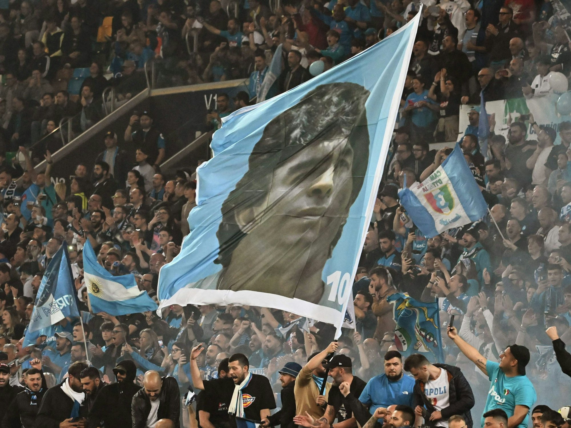 Die Fans von Napoli bejubeln die Meisterschaft in Udine mit einer riesigen Maradona-Fahne