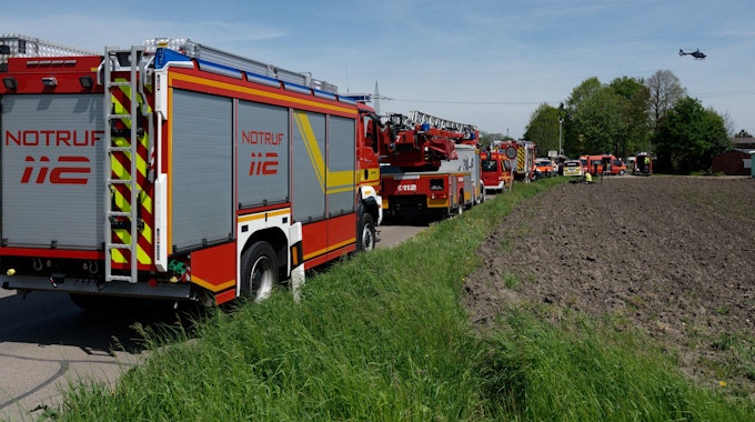 Fahrzeuge der Einsatzkräfte stehen am 4. Mai 2023 auf einer zum Unfallort führenden Straße. Bei dem Unfall in Hürth bei Köln sind am Donnerstag nach Angaben der Bundespolizei zwei Menschen ums Leben gekommen.