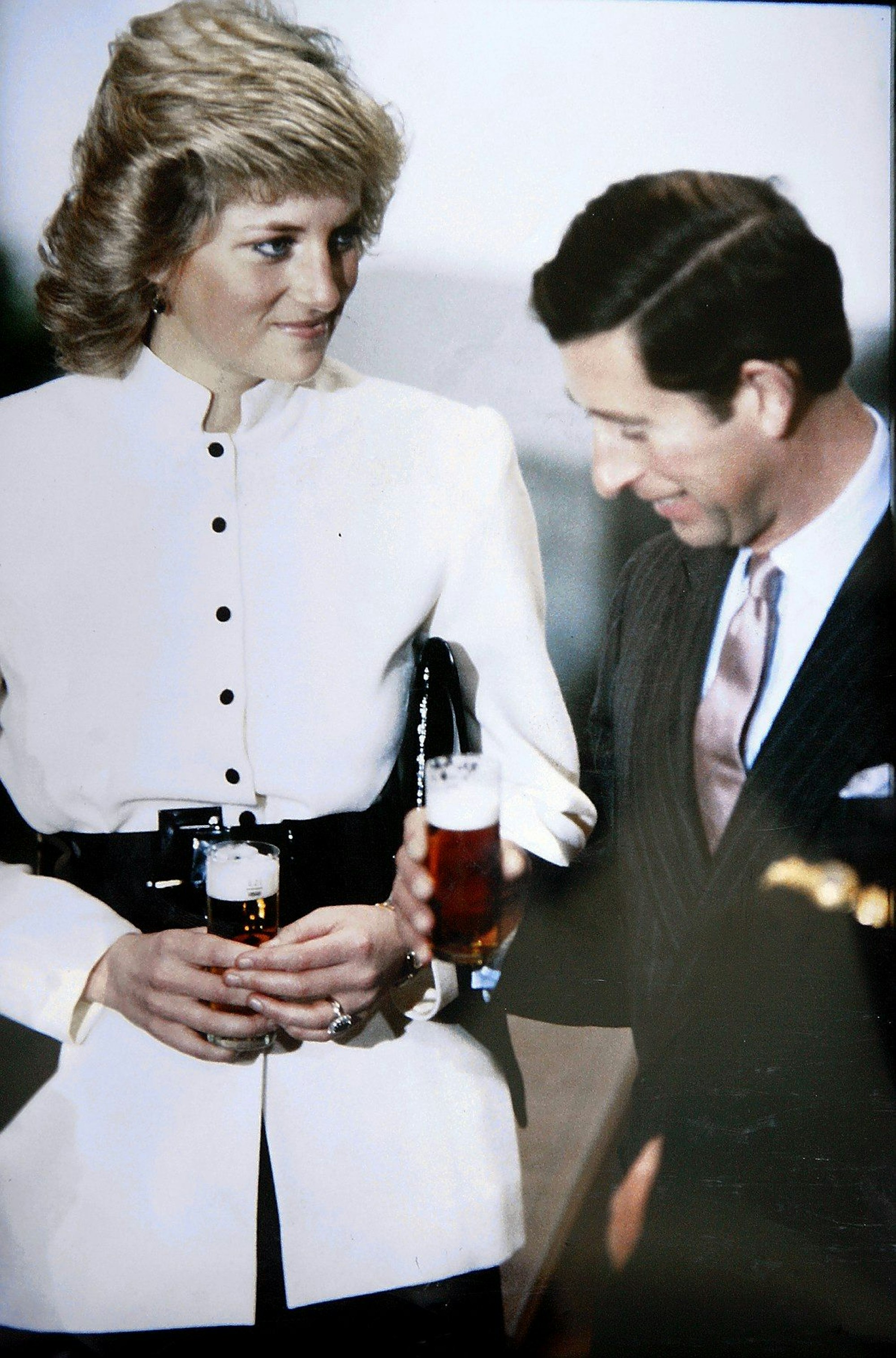 Prinzessin Diana und Prinz Charles bei ihrem Kölnbesuch 1987. Sie halten beide ein Kölschglas in der Hand.