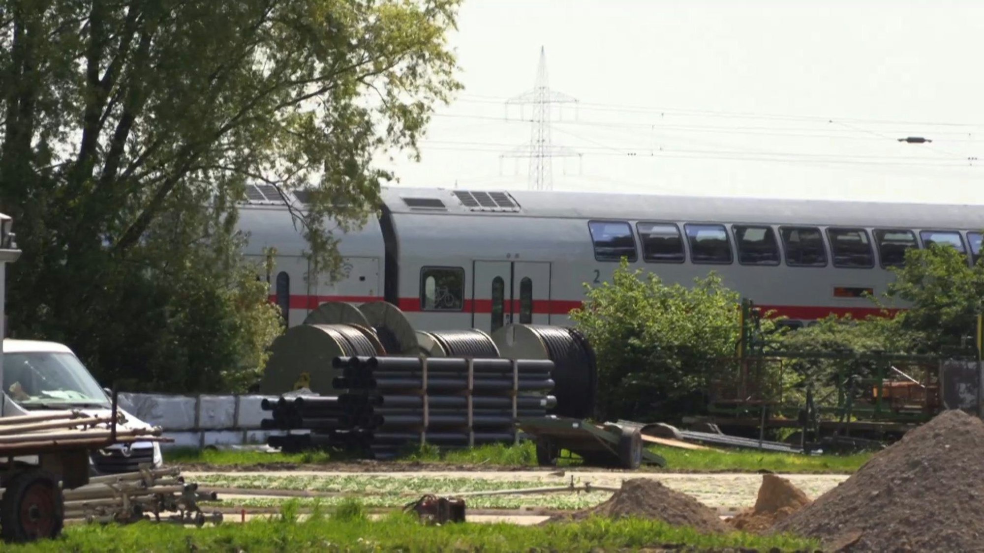 Hürth: Ein Zug steht auf der Bahnstrecke nahe des Unfallortes. Der IC ist in eine Gruppe von Arbeitern gefahren.