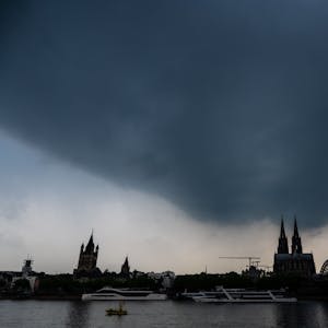 Dunkle Gewitterwolken ziehen über dem Kölner Dom auf. Der Deutsche Wetterdienst warnt vor unwetterartigen Gewittern mit Starkregen und Hagel im Rheinland. (Symbolbild)