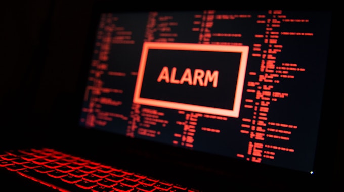 Ein rot beleuchteter Computer zeigt eine fiktive Fehlermeldung an (gestellte Szene).&nbsp;