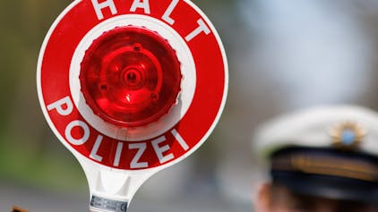Ein Polizist zieht ein Fahrzeug am 21. April 2023 in Nürnberg mit seiner Kelle aus dem Verkehr.