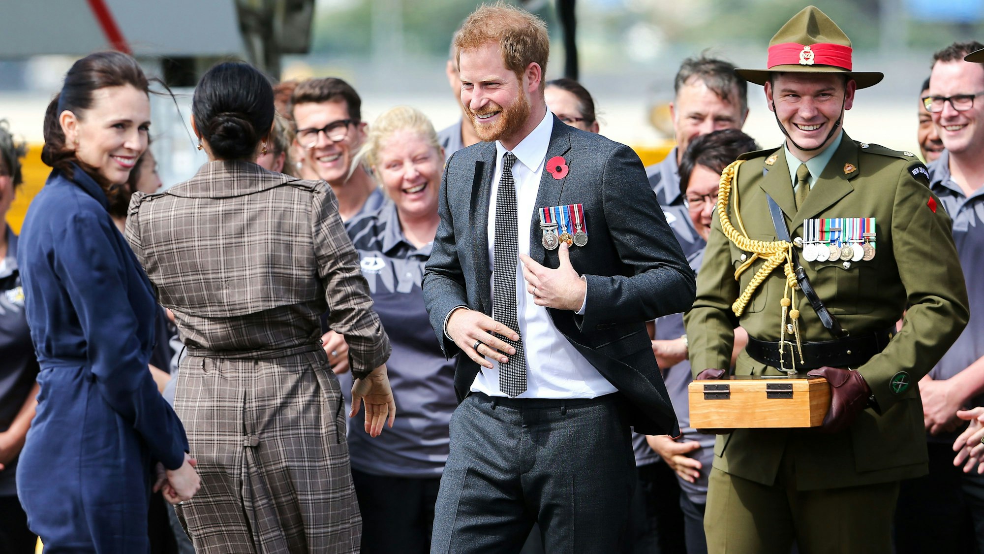 Prinz Harry, Herzog von Sussex, lacht mit Meghan, Herzogin von Sussex, und Premierministerin Jacinda Ardern, als Mitglieder des neuseeländischen Invictus Games-Teams am 28. Oktober 2018 in Wellington, Neuseeland, am Militärterminal des internationalen Flughafens von Wellington ankommen.
