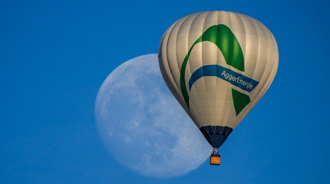 Ein Heißluftballon mit dem Logo der Aggerenergie fliegt am Himmel. Im Hintergrund des Ballons ist groß der Mond zu sehen.&nbsp;