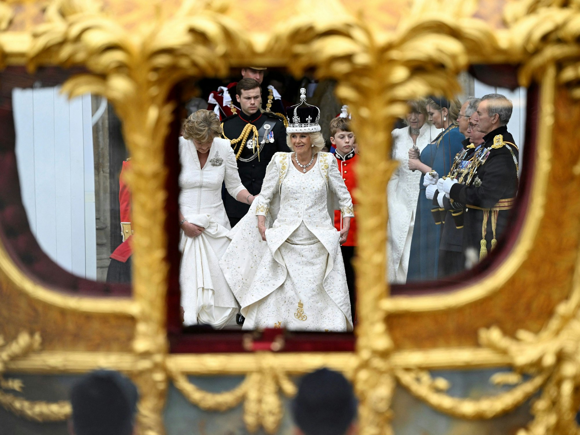 Die britische Königin Camilla verlässt mit der Krone von Queen Mary die Westminster Abbey nach der Krönungszeremonie und steigt in die Goldene Staatskutsche.